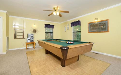 a pool table in a living room with a ceiling fan at Among The Clouds 2240 in Gatlinburg
