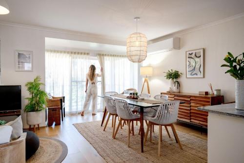 a woman is standing in a living room at Sandy Days in Mollymook Beach in Mollymook
