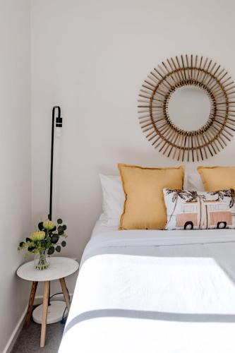 a bedroom with a bed with a mirror on the wall at Sandy Days in Mollymook Beach in Mollymook