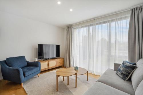 a living room with a couch and a tv at Skyliine Serenity in Wanaka