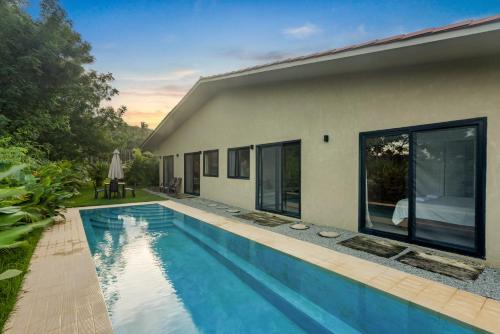 a swimming pool in front of a house at Casa Ola - Tropical Beachside Escape in Playa Venao
