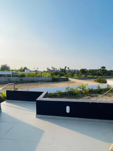 a view of a garden with black benches at The A-Frame house in Kūvattūr