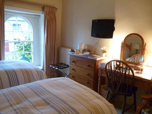 ein Schlafzimmer mit einem Bett und eine Kommode mit einem Spiegel in der Unterkunft Mickley Bed and Breakfast in Mickley