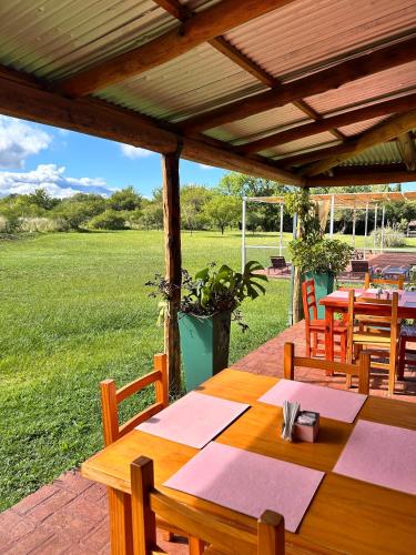 a wooden table and chairs on a patio at cabañas Villa de las rosas in Villa de Las Rosas