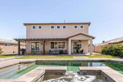 a home with a swimming pool and a house at Beautiful 5 BR house Huge Pool SPA BBQ in Indio in Indio