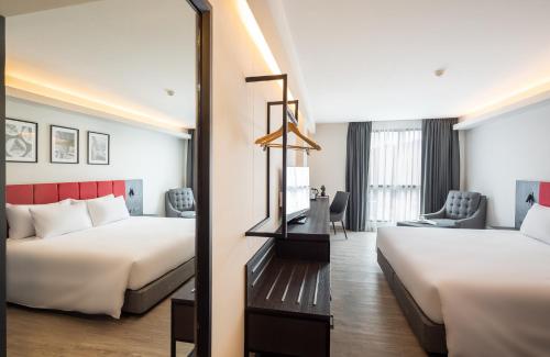 a hotel room with two beds and a mirror at Travelodge Phuket Town in Phuket Town