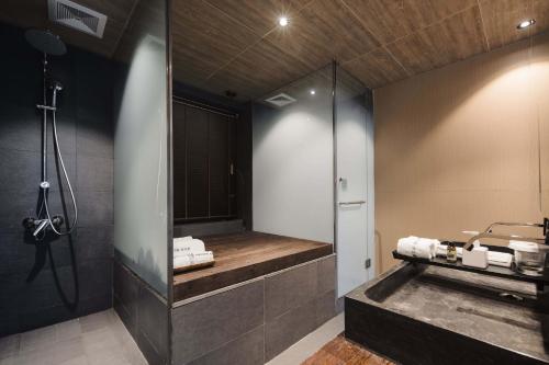 a bathroom with a shower and a sink and a mirror at 青城山坐忘森林疗愈酒店 in Dujiangyan