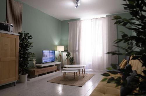 ヴェローナにあるApartHotel Verona Centro - Teatro Filarmonicoのソファとテーブルとテレビのあるリビングルーム