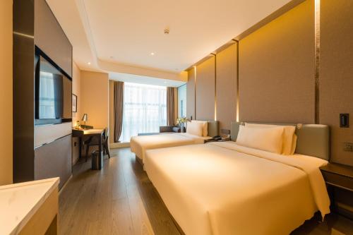 a hotel room with two beds and a television at Atour Hotel Beijing You'anmen West Tieying Subway Station in Beijing