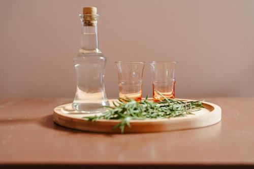 a bottle and two glasses sitting on a wooden table at Michaella Studios in Plaka