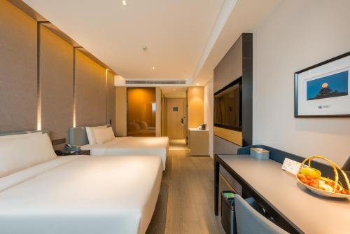 a hotel room with two beds and a table at Atour Hotel Beijing You'anmen West Tieying Subway Station in Beijing
