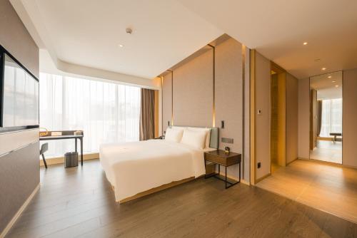 a bedroom with a white bed and a large window at Atour Hotel Beijing You'anmen West Tieying Subway Station in Beijing