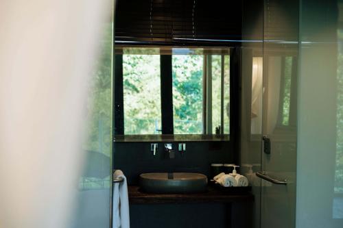 a bathroom with a sink and a window at 青城山坐忘森林疗愈酒店 in Dujiangyan