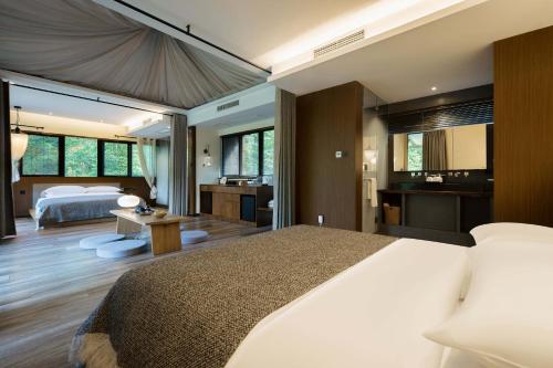 a bedroom with a large bed and a bathroom at 青城山坐忘森林疗愈酒店 in Dujiangyan