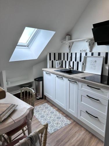 une cuisine blanche avec une lucarne et une table et une cuisine dans l'établissement Cabello - Vannes centre 2 personnes St Patern, à Vannes