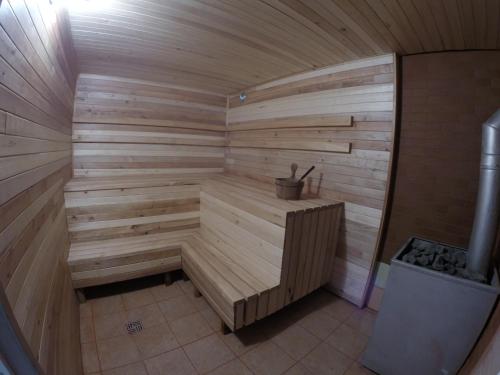 a wooden sauna with a bench in a room at Viesu Māja Arnicāni in Ragaciems