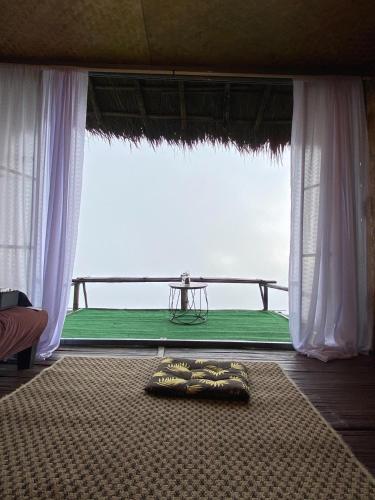 a room with a bed and a table in front of a window at ASA Private Homestay - บ้านนายพราน แนววินเทจ in Ban Huai Khai