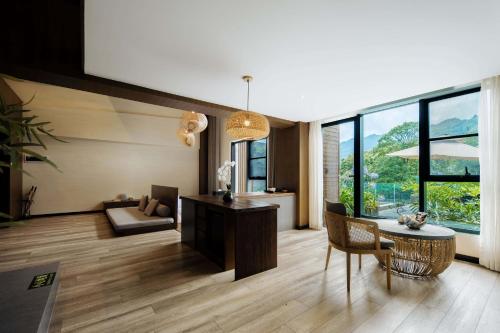 a living room with a table and a chair at 青城山坐忘森林疗愈酒店 in Dujiangyan