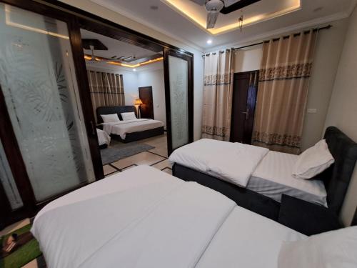 a hotel room with two beds and a mirror at Pinewood Guest House, Islamabad in Islamabad