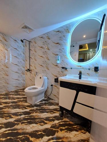 a bathroom with a toilet and a sink and a mirror at Pinewood Guest House, Islamabad in Islamabad