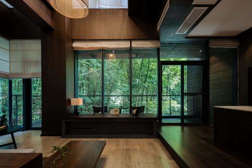 a room with a large window with a cat sitting on a bench at 青城山坐忘森林疗愈酒店 in Dujiangyan