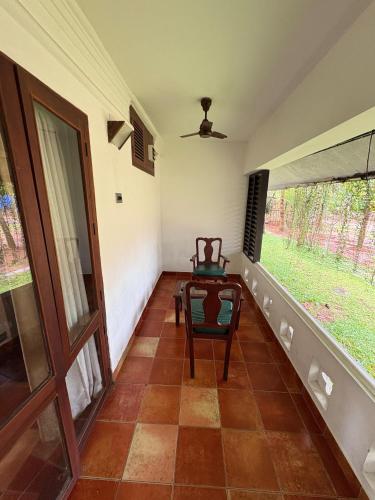 an empty room with a chair and a window at Kumarakom Tharavadu - A Heritage Hotel, Kumarakom By Perfect Stays in Kumarakom