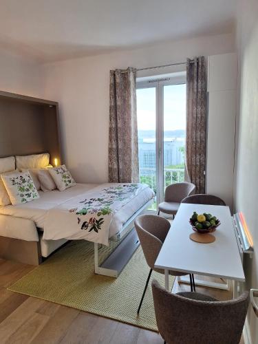 une chambre avec un lit et une table avec des chaises dans l'établissement Au Cœur du Cap d'Antibes pour 4 personnes, à Antibes