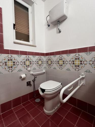 a bathroom with a toilet and a window at Oasi Cuore in Castellammare di Stabia