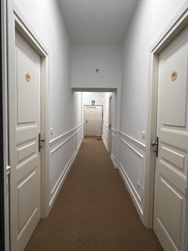 a hallway with white doors and a long corridor at Oasi Cuore in Castellammare di Stabia