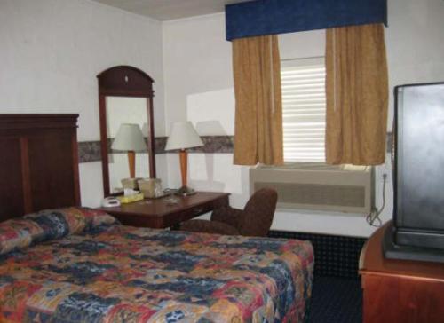 a hotel room with a bed and a desk and a television at Martin House Motel Brookfield in Brookfield