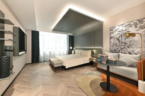 a hotel room with a bed and a couch at Atour S Hotel North Guoshang Road, Yinchuan Lan Waiting Valley in Yinchuan