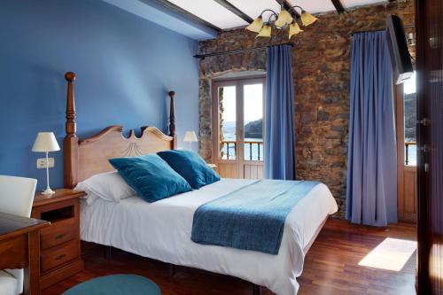 a bedroom with blue walls and a bed with blue pillows at Katrapona in Getaria