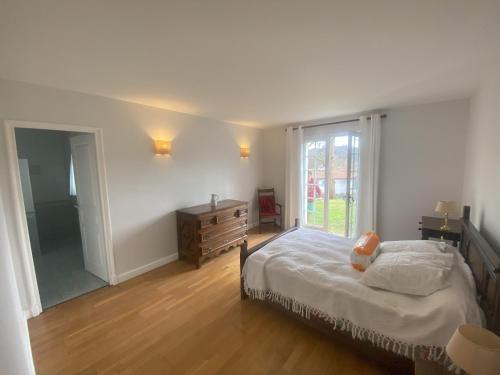 une chambre avec un lit, une commode et une fenêtre dans l'établissement Maison 5 chambres Cambo les bains 64, à Peyrehorade