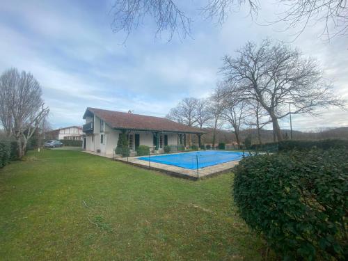 une maison avec une piscine dans une cour dans l'établissement Maison 5 chambres Cambo les bains 64, à Peyrehorade
