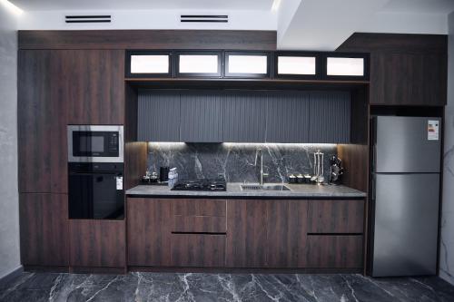 a kitchen with a sink and a stove and a refrigerator at RIO Hotel in Samarkand