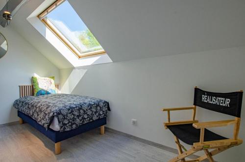 1 dormitorio en el ático con 1 cama y tragaluz en L'annexe, en Saint-Hilaire-sous-Romilly