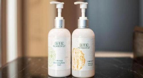 two bottles of shampoo sitting on a table at James Joyce Coffetel Harbin West High-speed Railway Station Wanda Plaza in Harbin