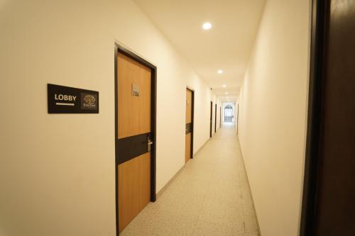 a corridor of a hallway with doors and a long aisle at Evertree Hotel in Balikpapan