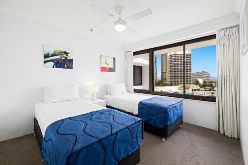 a bedroom with two beds and a large window at South Pacific Plaza - Official in Gold Coast