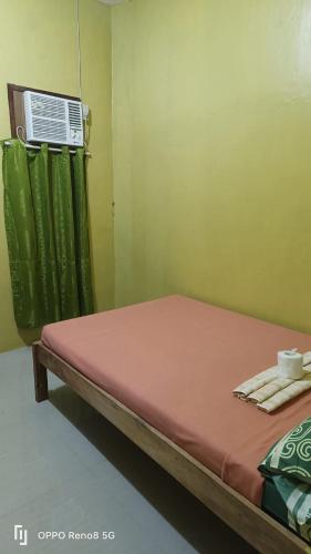 a bed in a room with a air conditioner at Oringo Residence Apartelle in San Vicente