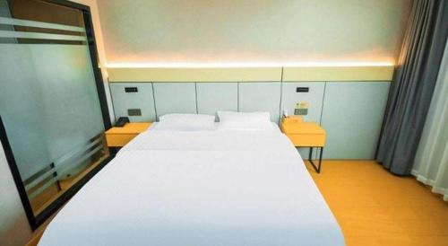 a bedroom with a large white bed in a room at Shell Hotel Wuhu Jiujiang District Daqiao Town Huashan Road in Wuhu