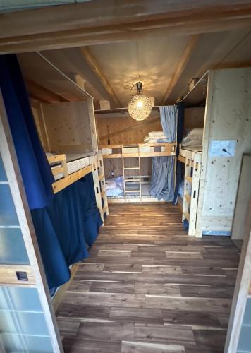 a room with bunk beds and a chandelier at 高野山ゲストハウス ラフテル Koyasan Guest House Laugh Tale in Hashimoto
