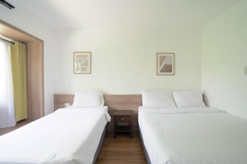 two beds sitting next to each other in a room at Dream Golftel by Dream Residences in Manolo Fortich