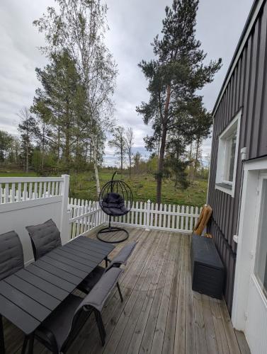 a wooden deck with a bench and a table and chairs at Cozy countryside Appartment in Örebro