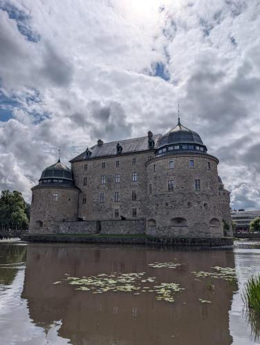 an old building with two domes on top of a body of water at Cozy countryside Appartment in Örebro