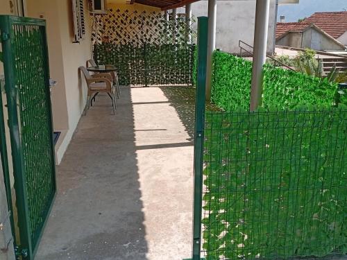 a green fence with a chair in a yard at Apartman Lena in Dobrota