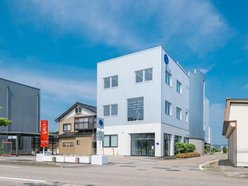 a white building on the side of a street at métisse stay in Nanto
