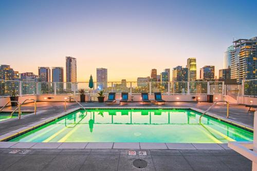 a swimming pool on the roof of a building with a city skyline at DTLA 2BR Loft with Hot Tub & Rooftop Pool! in Los Angeles