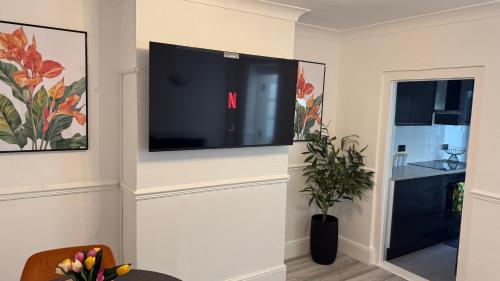 a living room with a flat screen tv on a wall at Luna Homes in Dartford