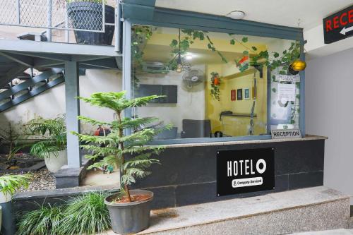a tree in a pot in front of a restaurant at Hotel O Pacific Mall Rajpur Road in Dehradun